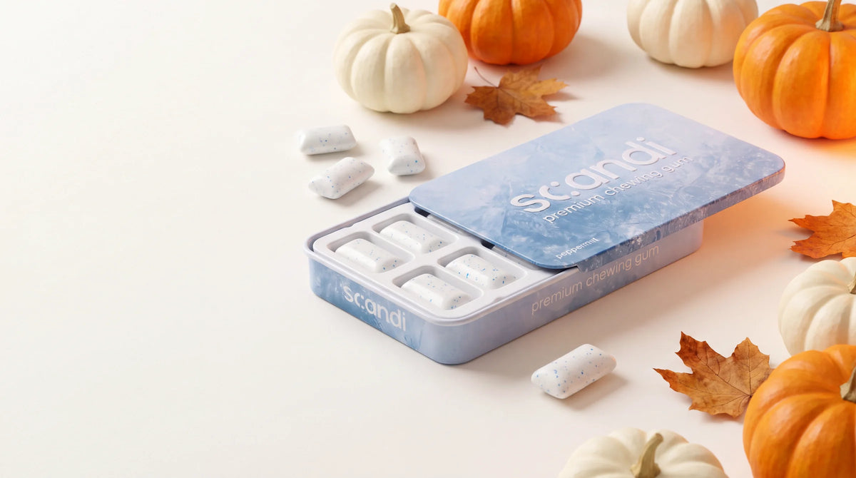 The Scandi Gum tin among white and orange pumpkins